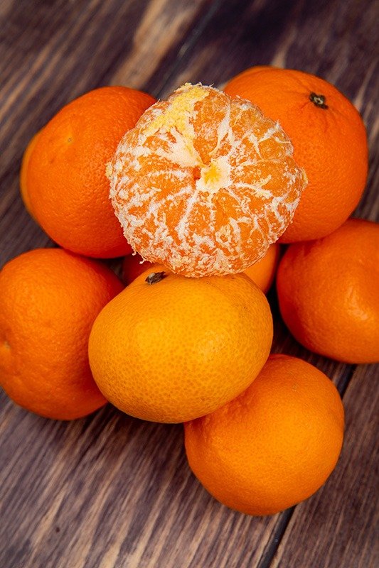 side view of fresh ripe tangerines on rustic wooden background