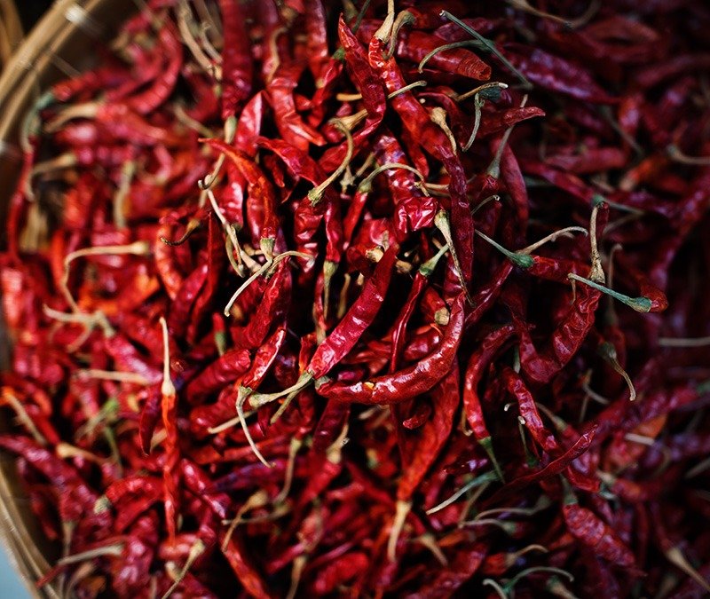 various dried fruits in a bowl on a trivet , on the marble background