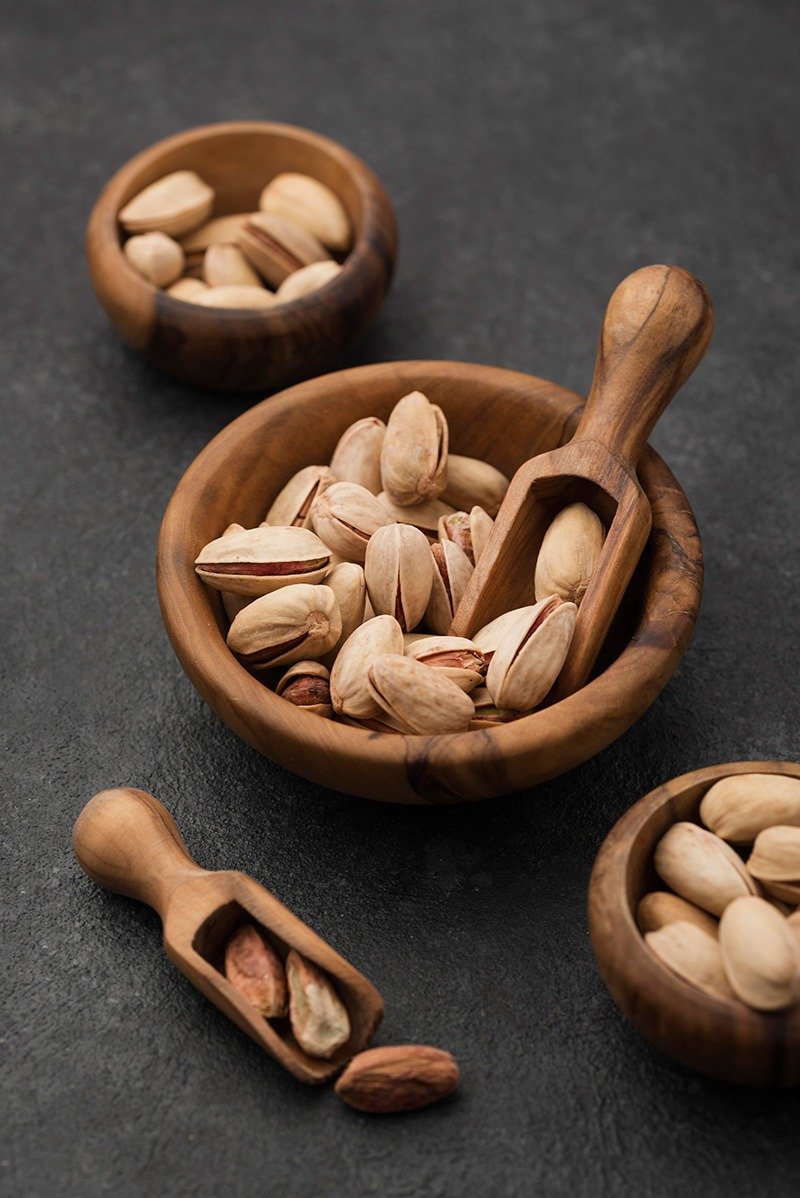 pistachio nuts wooden bowls with spoons